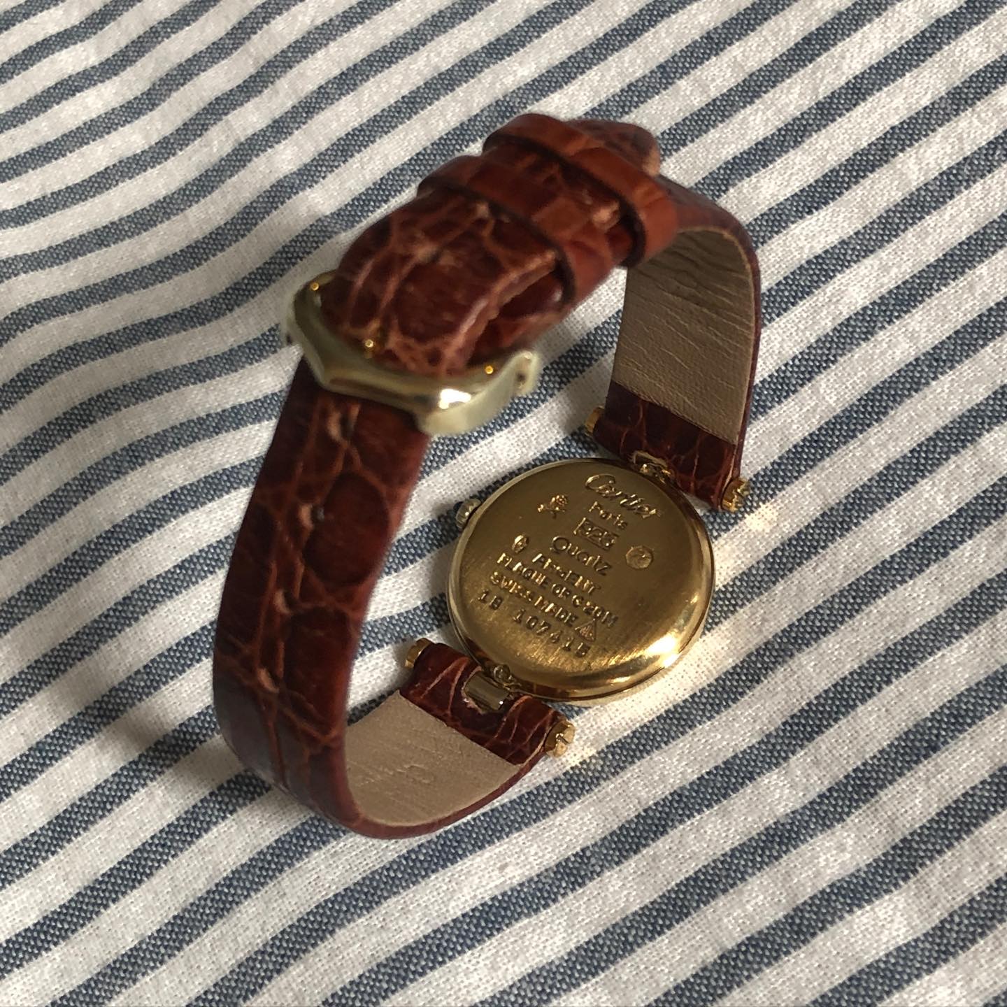Casebacks of the Cartier and Movado shown together