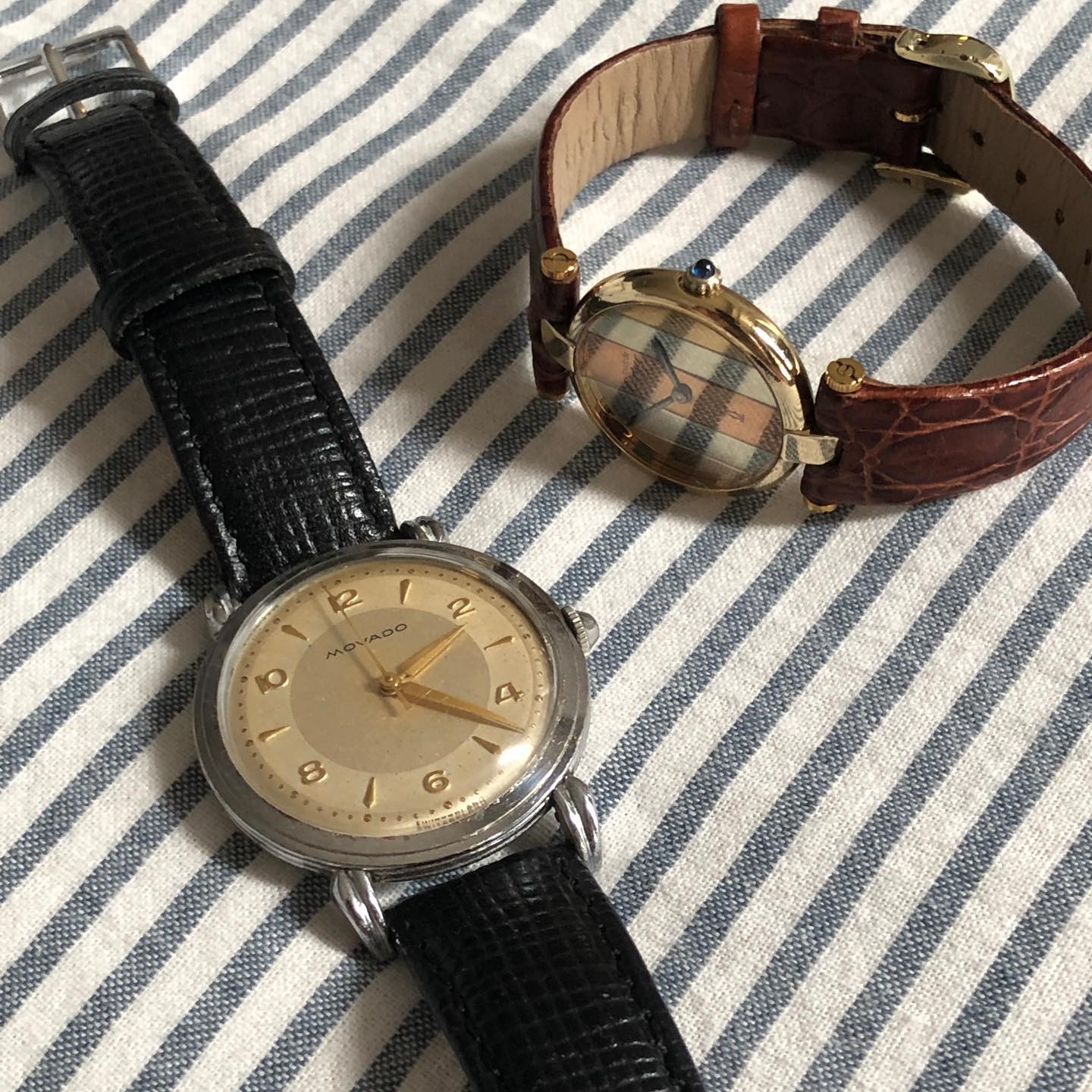 Movado bullseye watch in the foreground, beside a Cartier Trinity Vendome